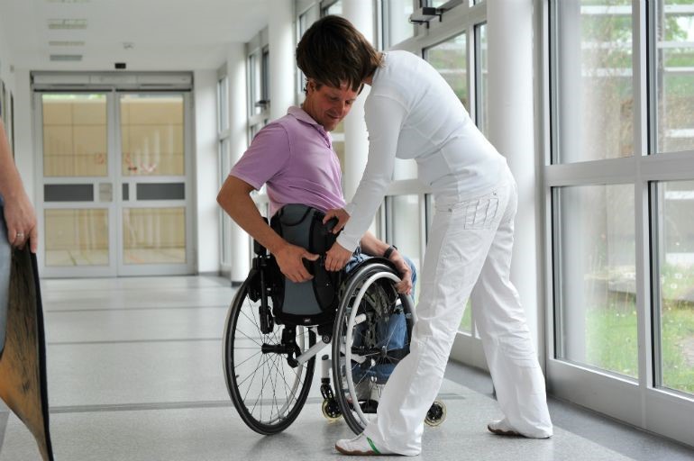 A man having his wheelchair checked over by a technician