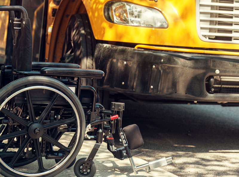 A wheelchair next to a parked school bus